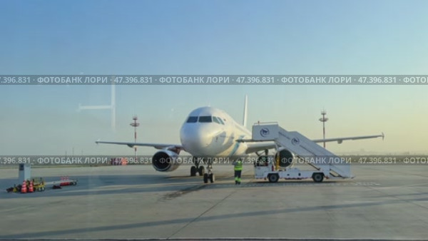 Mineralnye Vody, Russia - 09.03.2024: Passenger aircraft with boarding stairs, prepared to taking off on runway, waiting for boarding passengers, baggage before flight. Airport trip concept. Footage. Редакционное видео, видеограф Ирина Михайличенко / Фотобанк Лори