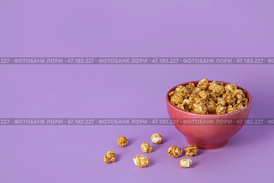 Миска с вкусным попкорном на фиолетовом фоне. Стоковое фото, фотограф Pixel_shot / Фотобанк Лори