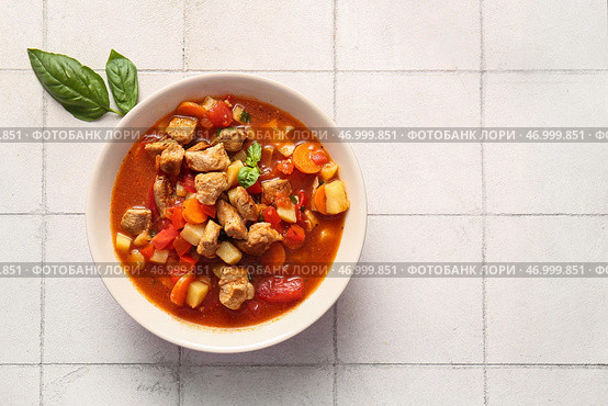 Миска вкусного говяжьего рагу на фоне белой плитки. Стоковое фото, фотограф Pixel_shot / Фотобанк Лори