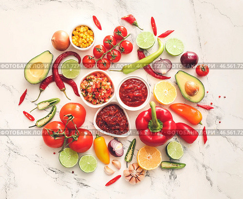 Миски вкусных соусов сальса с продуктами на белом фоне. Стоковое фото, фотограф Pixel_shot / Фотобанк Лори