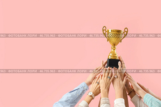 Много рук с золотым кубком на розовом фоне. Стоковое фото, фотограф Pixel_shot / Фотобанк Лори