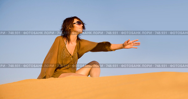 Молодая девушка, сидящая в песчаных дюнах. Стоковое фото, фотограф Алексей Кузнецов / Фотобанк Лори