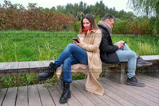 Молодая пара гуляет в лесопарке и пользуются смартфоном. Смартфон в руках. Стоковое фото, фотограф Терехова Марина / Фотобанк Лори