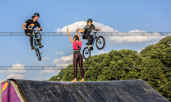 Молодой человек участвует в соревнованиях по BMX на велосипеде на специальной площадке фестиваля Extreme Fest в центре города Москва, Россия (2018 год)/ Young men doing tricks in the air on a BMX bikes. BMX riders. Редакционное фото, фотограф Iva Noel / Фотобанк Лори