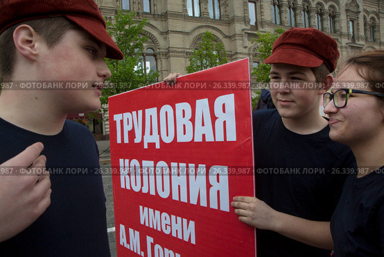 Молодые люди держат плакат с надписью "Трудовая колония имени А.М. Горького" на Красной площади города Москвы во время церемонии приема в пионеры, Россия (2017 год). Редакционное фото, фотограф Николай Винокуров / Фотобанк Лори