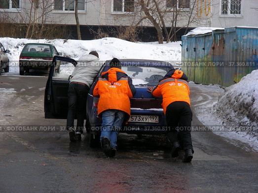 Молодые люди толкают заглохший на дороге автомобиль. Новосибирская улица. Район Гольяново. Город Москва (2013 год). Редакционное фото, фотограф lana1501 / Фотобанк Лори