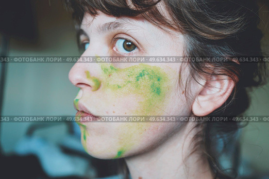 Moody portrait of a young woman with her face painted of green. Стоковое фото, агентство Ingram Publishing / Фотобанк Лори
