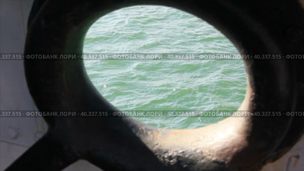 Морская поверхность с небольшими волнами видна сквозь швартовое отверстие. Стоковое видео, видеограф Цыбин Вадим / Фотобанк Лори