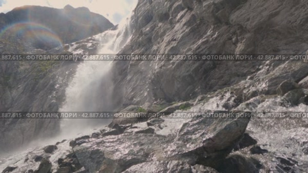 Мощный поток воды падает со скалы. Этичный водопад. Камера движется перед скалами и потоком воды. Брызги летят на объектив. Белые отвесные скалы и водопад. Стоковое видео, видеограф Воловодов Владимир / Фотобанк Лори