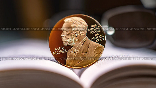 Moscow December 03 2024. Alfred Nobel's image on gold coin on physics book and reading glasses in background. Nobel Prize award. Nobel Prize for Literature concept. Редакционное фото, фотограф Скрипачев Антон / Фотобанк Лори
