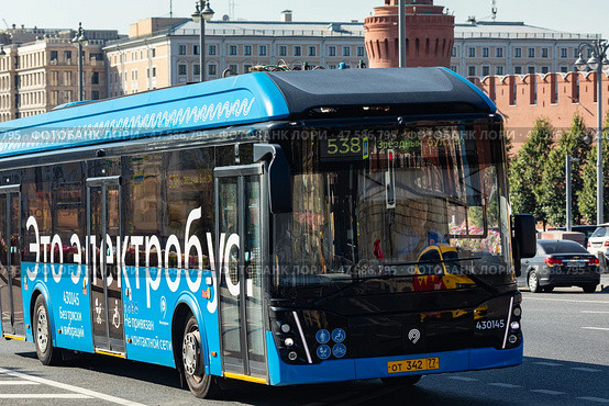 Moscow, Russia - 08.26.2024: Blue electrobus drives down the street in Moscow, front side view. Electric bus in motion. Moscow transport. Редакционное фото, фотограф Ирина Михайличенко / Фотобанк Лори