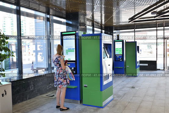Moscow, Russia - Aug 21. 2023. Woman buying a ticket through the terminal in Zelenograd-Kryukovo station D3 of surface metro diameter. Редакционное фото, фотограф Володина Ольга / Фотобанк Лори