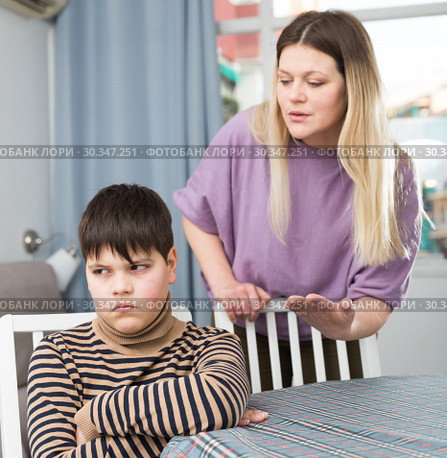 Mother and offended son arguing in domestic interior. Стоковое фото, фотограф Яков Филимонов / Фотобанк Лори