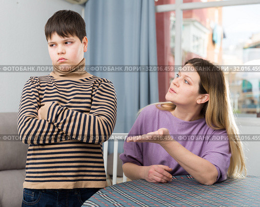 Mother and offended son arguing in domestic interior. Стоковое фото, фотограф Яков Филимонов / Фотобанк Лори