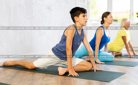 Mother, grandmother and teen son do exercise dove pose, Eka Pada Rajakapotasana. Стоковое фото, фотограф Яков Филимонов / Фотобанк Лори