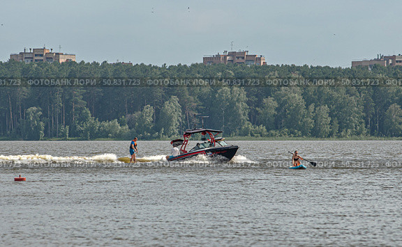 Моторная лодка мчится по воде с человеком на водных лыжах. город Железногорск, Красноярский край, Редакционное фото, фотограф Анатолий Володин / Фотобанк Лори