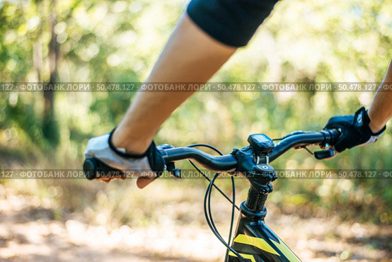 Mountain cyclists grasp the bike handle, focusing on the bicycle neck. Стоковое фото, агентство Ingram Publishing / Фотобанк Лори