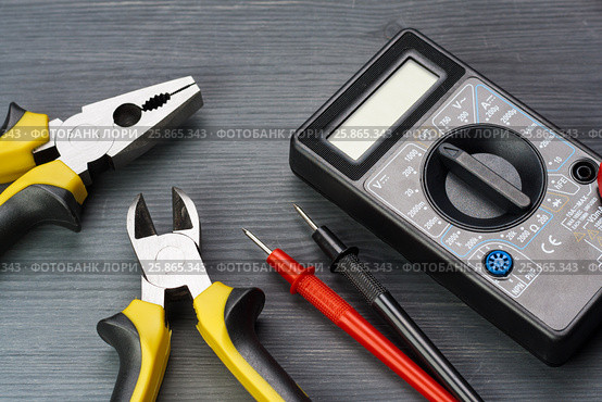 Multimeter and side cutters and pasatize on a dark wooden background. Стоковое фото, фотограф Alexander / Фотобанк Лори