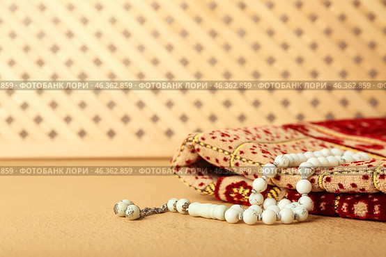 Muslim prayer mat and beads on color background. Стоковое фото, фотограф Pixel_shot / Фотобанк Лори