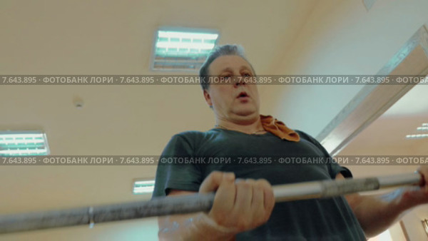 Мужчина делает упражнения со штангой. Стоковое видео, видеограф Данил Руденко / Фотобанк Лори