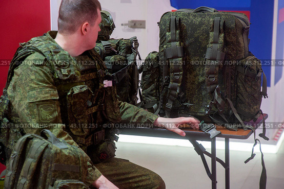 Мужчина демонстрирует экипировку российского военнослужащего на выставке-форуме "Россия" на территории выставочного комплекса ВДНХ в городе Москве, Россия (2024 год). Редакционное фото, фотограф Николай Винокуров / Фотобанк Лори