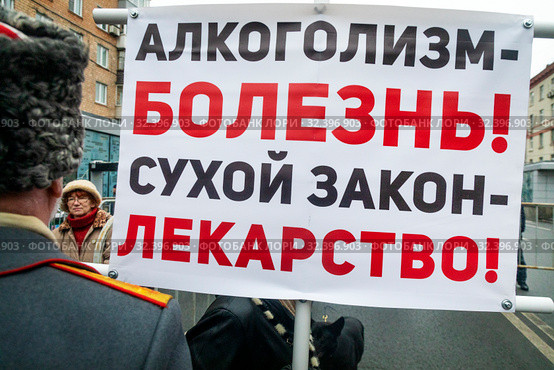 Мужчина держит плакат с надписью "Алкоголизм - болезнь! Сухой закон - лекарство!" на митинге в городе Москве, Россия (2019 год). Редакционное фото, фотограф Николай Винокуров / Фотобанк Лори