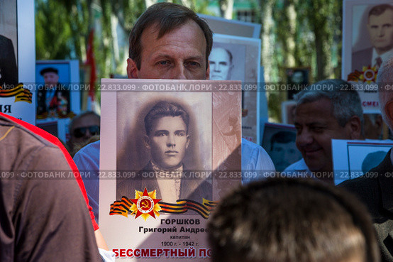 Мужчина держит портрет офицера, погибшего в Великой Отечественной войне, во время акции-шествия "Бессмертный полк" на центральной улице города Керчи в День Победы 9 мая, Республика Крым (2016 год). Редакционное фото, фотограф Николай Винокуров / Фотобанк Лори
