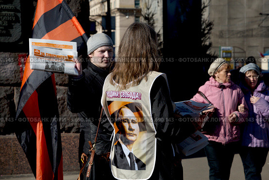 Мужчина держит раздает газету "За суверенитет!" около входа на митинг в поддержку русских на Украине на Тверской улице города Москвы 10 марта 2014. Редакционное фото, фотограф Николай Винокуров / Фотобанк Лори