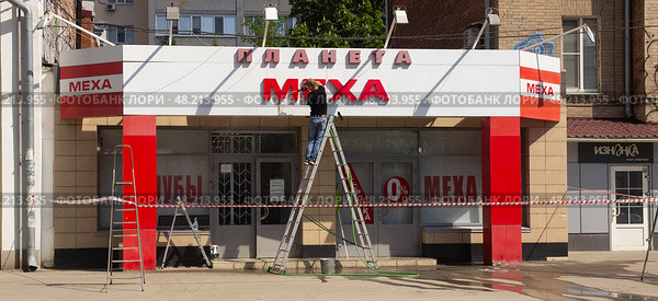 Мужчина моет фасад магазина Планета Меха. Саратов. Редакционное фото, фотограф Евгений Будюкин / Фотобанк Лори