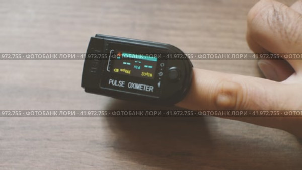 Мужчина надевает оксиометр на палец. Через некоторое время на ЖК-дисплее отображаются значения измерений. Мониторинг собственного здоровья. Стоковое видео, видеограф Воловодов Владимир / Фотобанк Лори