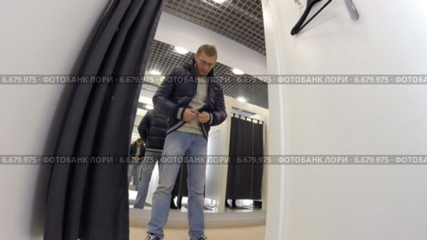 Мужчина примеряет куртку в магазине OSTIN (2013 год). Редакционное видео, видеограф Mikhail Erguine / Фотобанк Лори