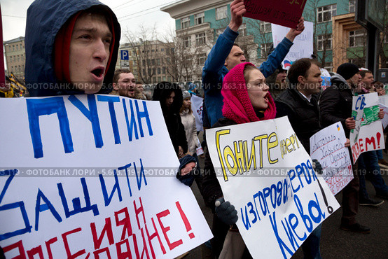 Мужчина с баннером "Путин, защити россиян на Украине!" на шествии в поддержку соотечественников на Украине, Москва (2014 год). Редакционное фото, фотограф Николай Винокуров / Фотобанк Лори