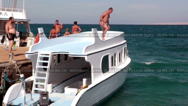 Мужчина собирается прыгнуть с крыши круизного катера в море. Красное море, Хургада, Египет (2015 год). Редакционное видео, видеограф Кекяляйнен Андрей / Фотобанк Лори