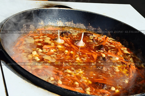 Мясо и овощи, приготовленные в огромном казане на улице. Приготовление плова. Стоковое фото, фотограф Staryh Luiba / Фотобанк Лори