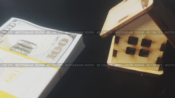 На черном столе с разных сторон разложены дом и пачка стодолларовых купюр. Стоковое видео, видеограф Ярославский Максим / Фотобанк Лори