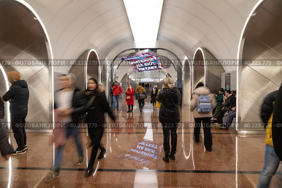 На станции "Рижская" Большой кольцевой линии Московского метрополитена (БКЛ) люди осматривают и фотографируют световую инсталляцию «Ковёр-самолет» с надписью "Интернет на БКЛ летает". Отражения на полу (2023 год). Редакционное фото, фотограф Наталья Николаева / Фотобанк Лори