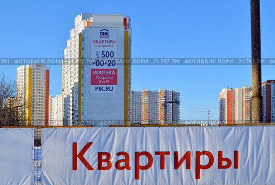 Надпись на растяжке "Квартиры" на фоне новостроек от группы компаний ПИК (2016 год). Редакционное фото, фотограф Александр Замараев / Фотобанк Лори
