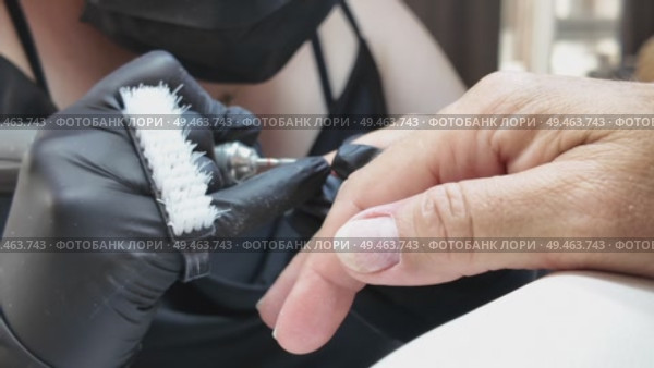 Nail technician using electric file for manicure in salon. Стоковое видео, видеограф Наталия Попова / Фотобанк Лори