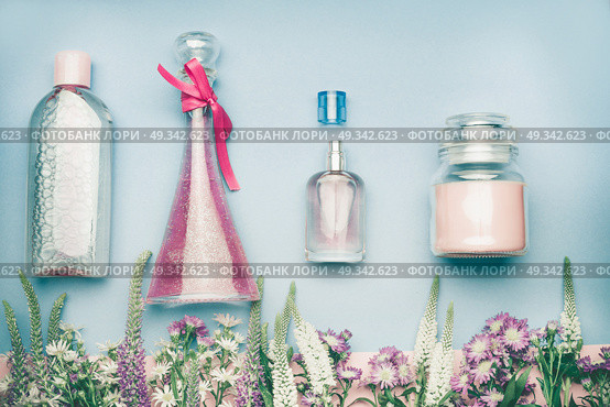 Natural cosmetic products. Jars and bottles with tonic , mist, perfume,cream ,tonic and micellar water on herbal leaves and wild flowers background, copy space for your text or branding , top view. Стоковое фото, агентство Ingram Publishing / Фотобанк Лори