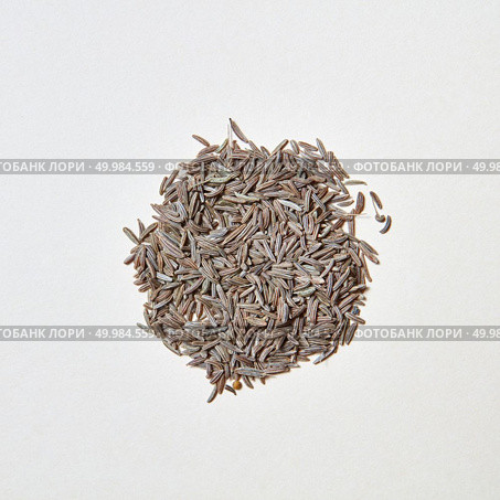 Natural organic herbal cumin - spice for cooking homemade healthy eating on a white with copy space. Healthy eating background. Flat lay. A round pattern of natural herb cumin seeds isolated on white background. Стоковое фото, агентство Ingram Publishing / Фотобанк Лори