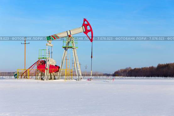 Нефтедобывающий станок на заснеженном поле в яркий солнечный день. Стоковое фото, фотограф Роман Иванов / Фотобанк Лори