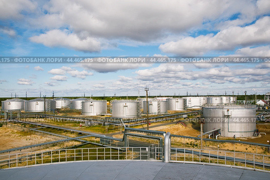 Нефтяные цистерны на фоне облачного неба. Стоковое фото, фотограф Павел Просянов / Фотобанк Лори