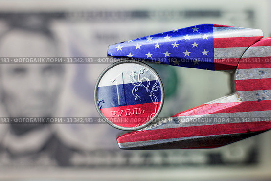 New Sanctions against the Russian economy. Pliers with USA flag squeezed the ruble with Russian flag. Стоковое фото, фотограф Evgenii Mitroshin / Фотобанк Лори