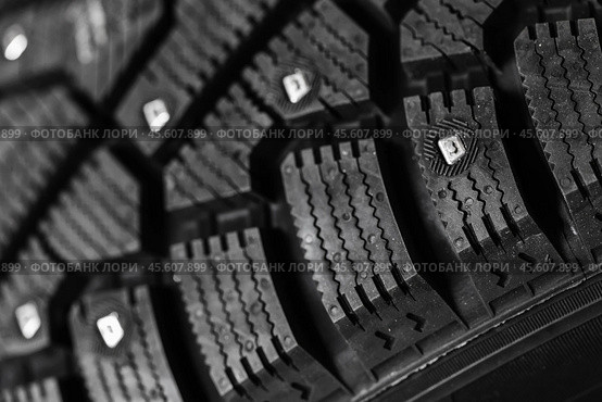 New studded car tire with metal studs embedded within the tread. Стоковое фото, фотограф EugeneSergeev / Фотобанк Лори