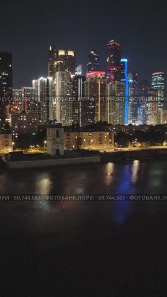 Ночные огни города Москвы. Высотки, новые дома. Яркие окна. Свет светящихся фонарей и отражение в воде набережной реки. Стоковое видео, видеограф Светлана Русских / Фотобанк Лори
