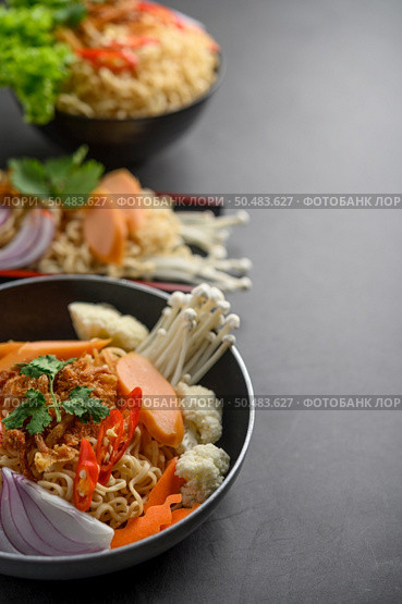 Noodles spicy in the Frying Pans with ingredients on black cement background, Selective focus. Стоковое фото, агентство Ingram Publishing / Фотобанк Лори