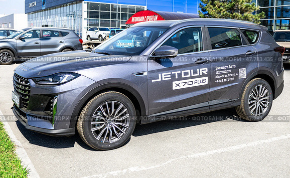 Новый автомобиль Jetour X70 Plus рядом с автосалоном официального дилера. Китайский производитель автомобилей. Редакционное фото, фотограф FotograFF / Фотобанк Лори