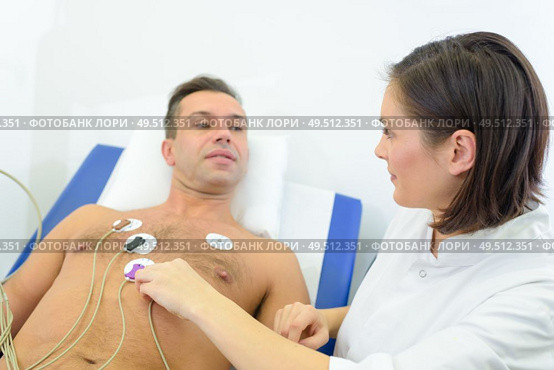 nurse attching pads to patients chest to monitor his heart. Стоковое фото, агентство Ingram Publishing / Фотобанк Лори