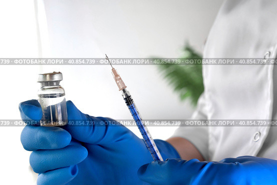 Nurse holds a Syringe and Vaccine Bottle in his Hand Close Up. Doctor ready to give an injection. Science. Medical Cosmetology, Beauty Treatment, Skin Care Concept. Covid 19, Monkeypox Vaccination. Стоковое фото, фотограф Марина Демидюк / Фотобанк Лори