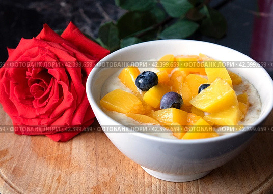 Oatmeal porridge with blueberries. Lovely breakfast with rose. Стоковое фото, фотограф Андрей Шалари / Фотобанк Лори